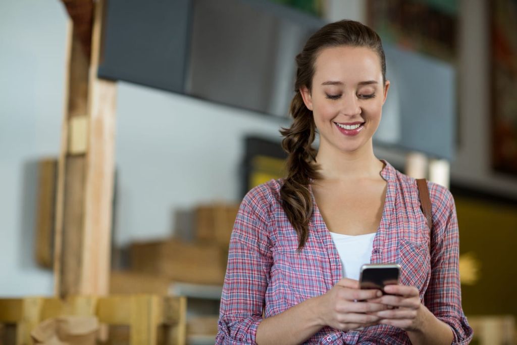 Woman engaging in eCommerce with mobile phone checking