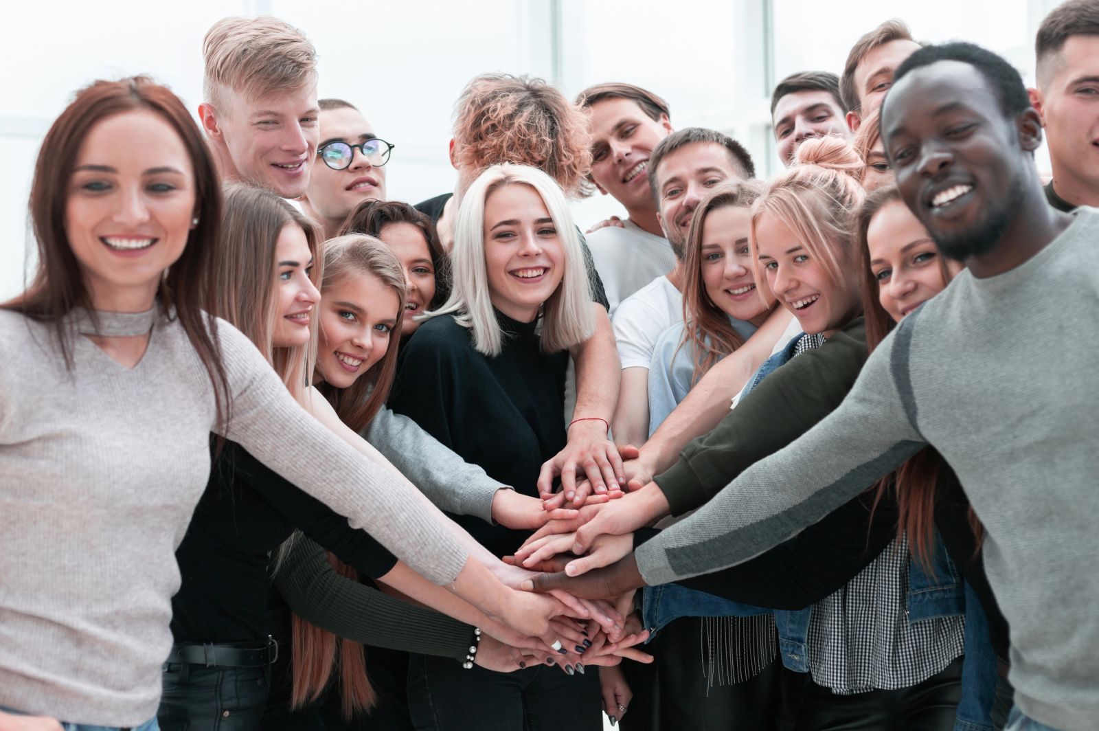A team stacking hands together before a project